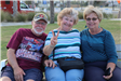 three adults sitting on bench