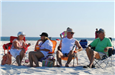 four people sitting on the beach