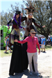 man standing by stilt walkers