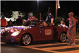 people riding in a car in the parade