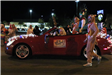 people riding in a car in the parade