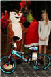 girl standing by new bike with rudolph and the grinch