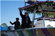 people throwing beads on a float