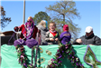 people throwing beads on mardi gras parade float