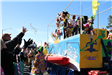 people throwing beads on mardi gras parade float