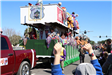 people throwing beads on mardi gras parade float