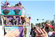 people throwing beads on mardi gras parade float