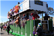 people throwing beads on mardi gras parade float