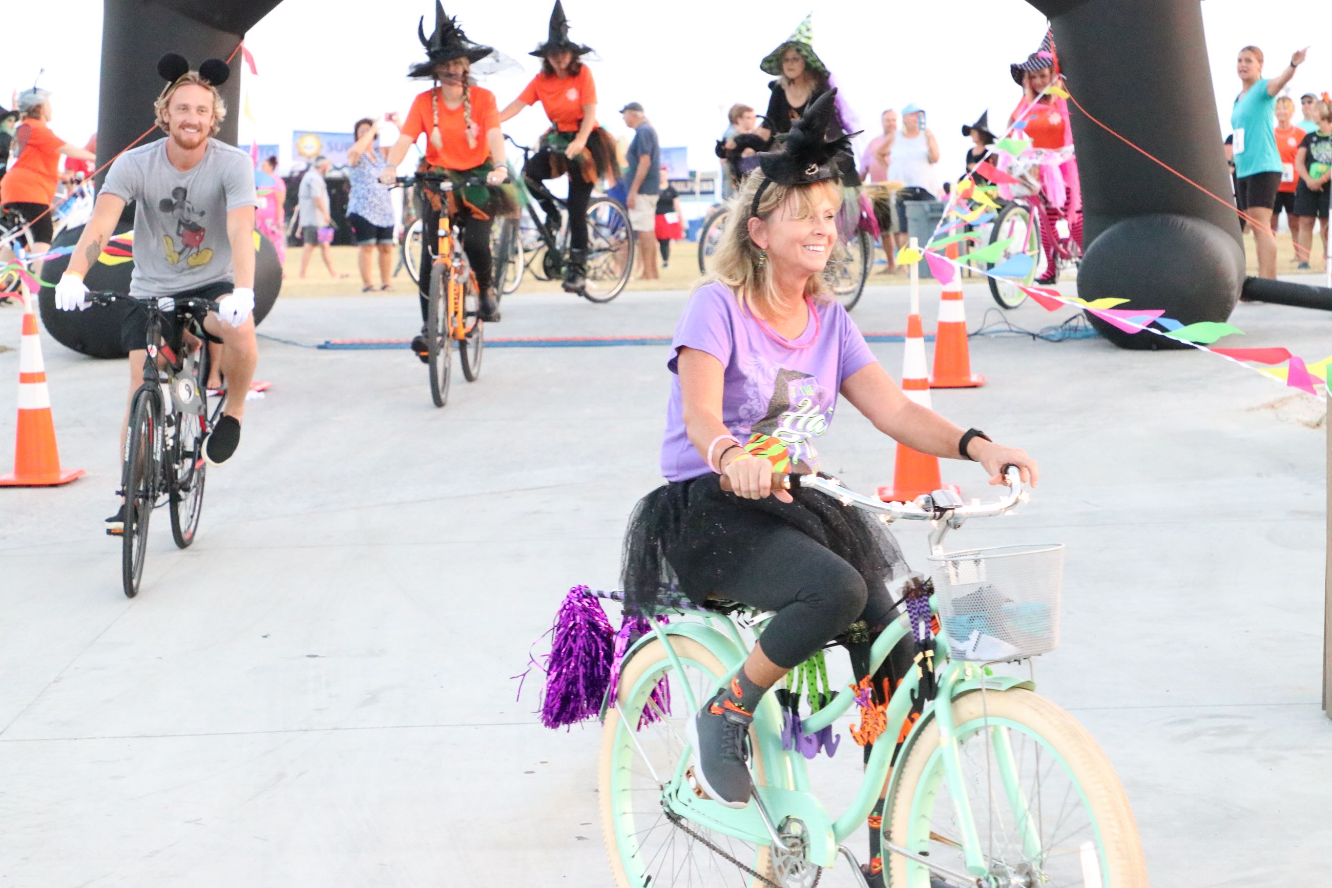 people dressed as witches riding bicycles