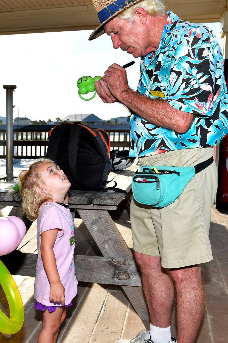 man making a child a balloon animal