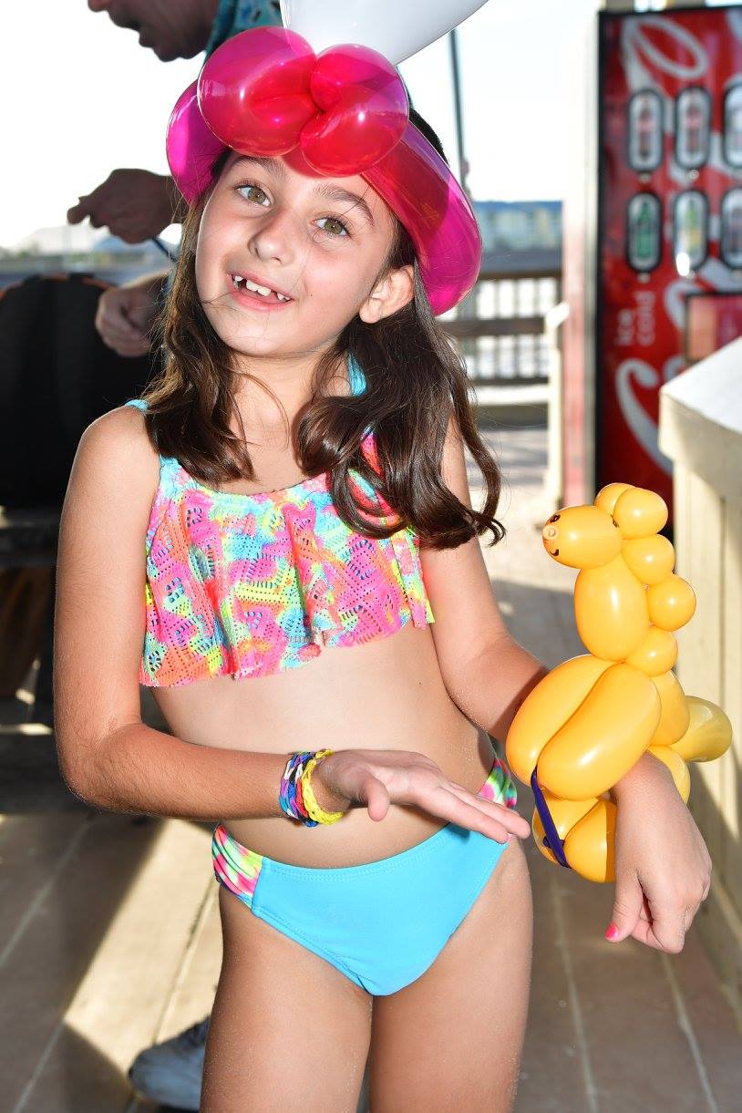 girl smiling with a balloon animal