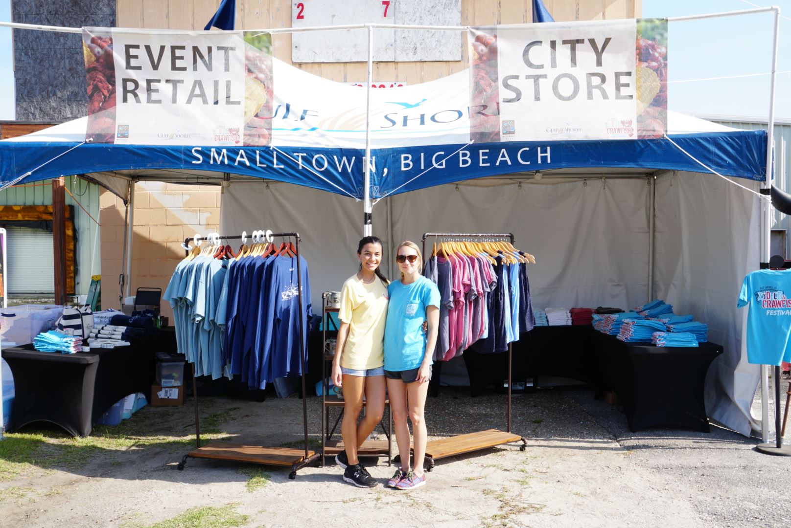 two women smiling in front of retail booth