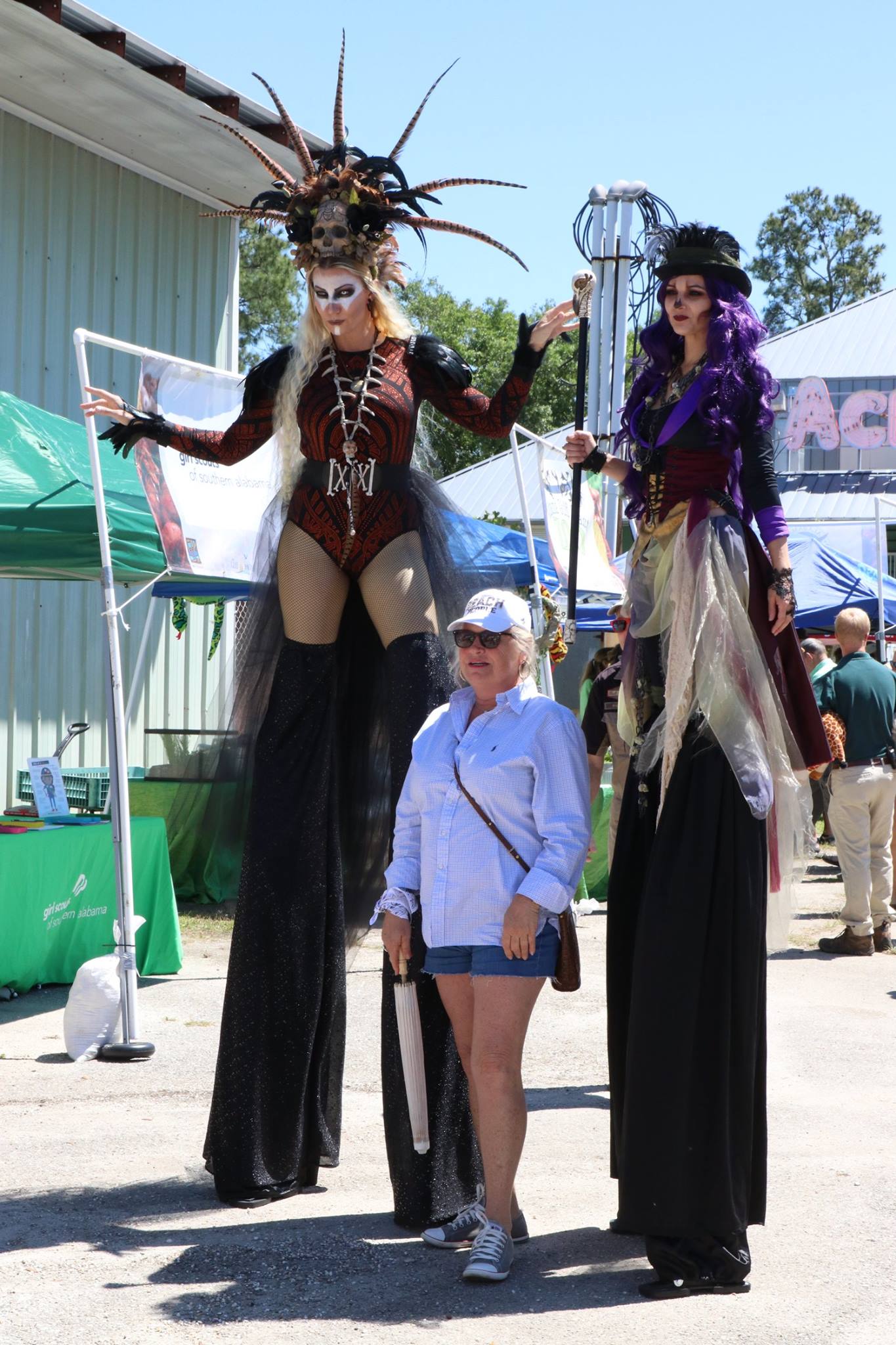 woman standing by stilt walkers