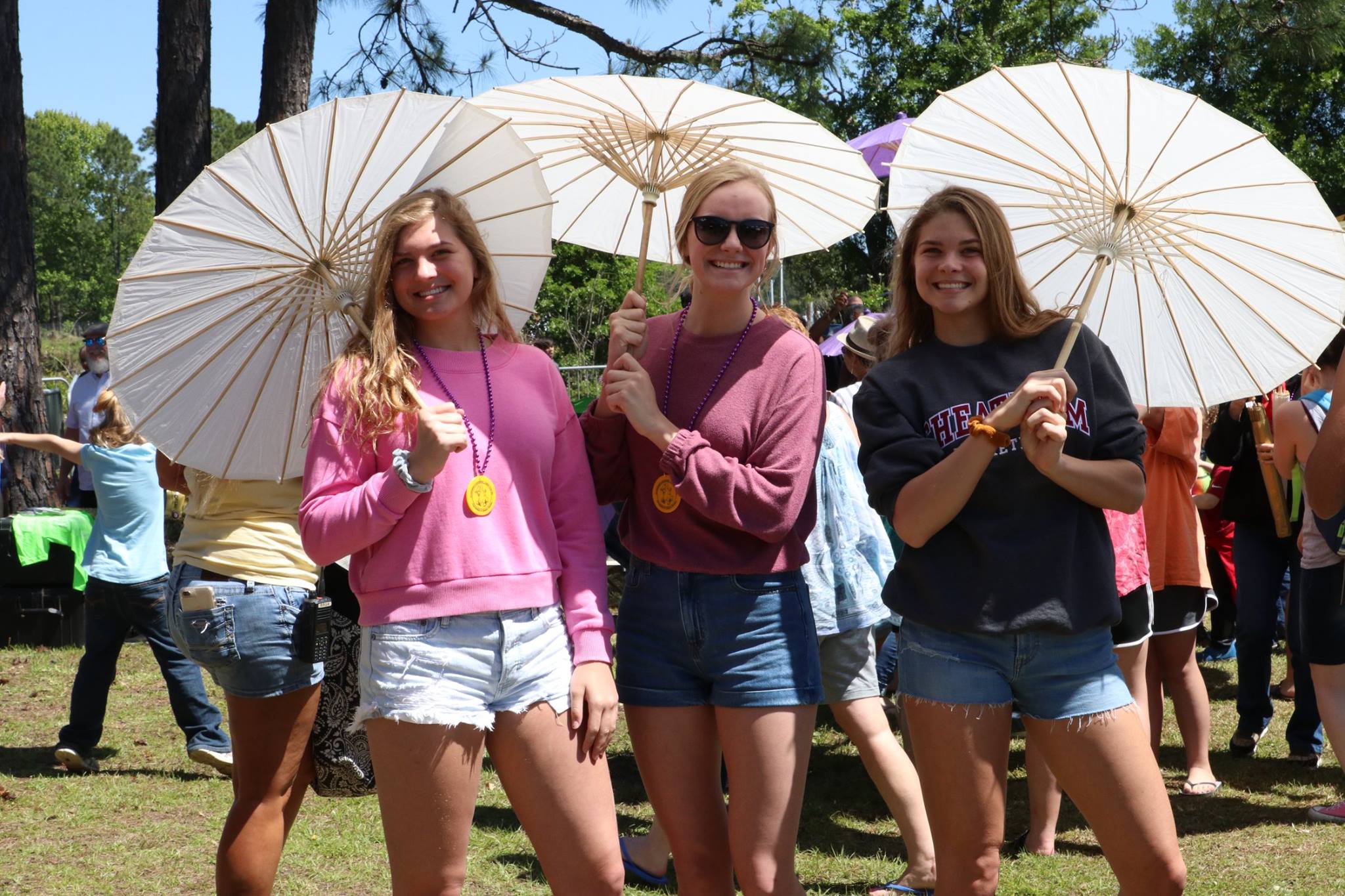three girls holding zydeco umbrellas