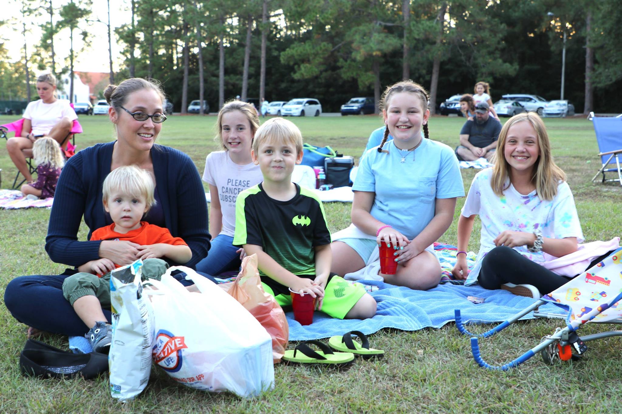 family sitting and smiling while they wait for the movie