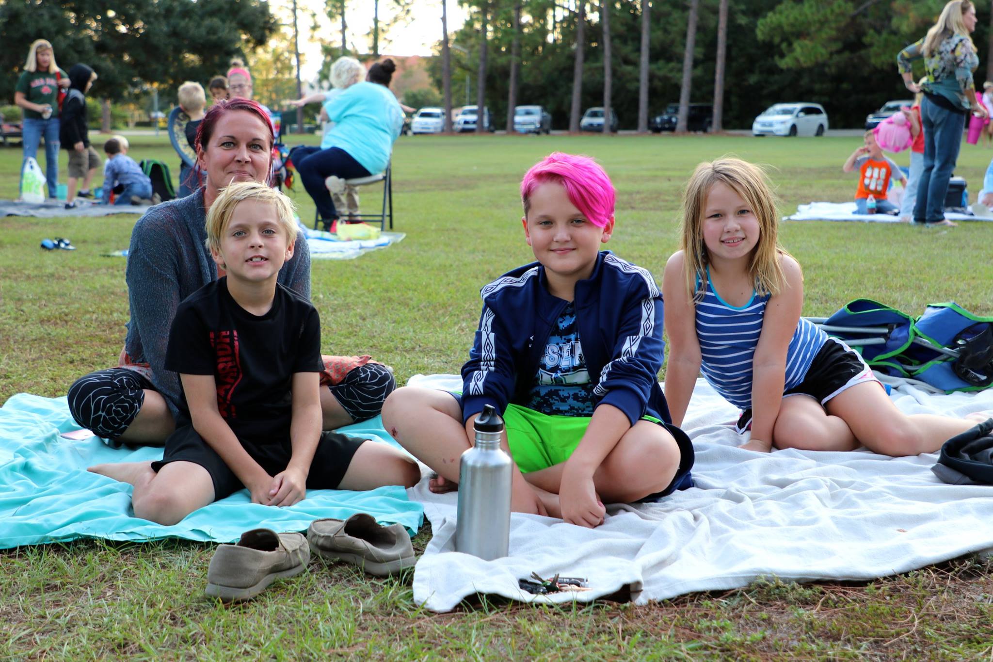 family sitting and smiling while they wait for the movie