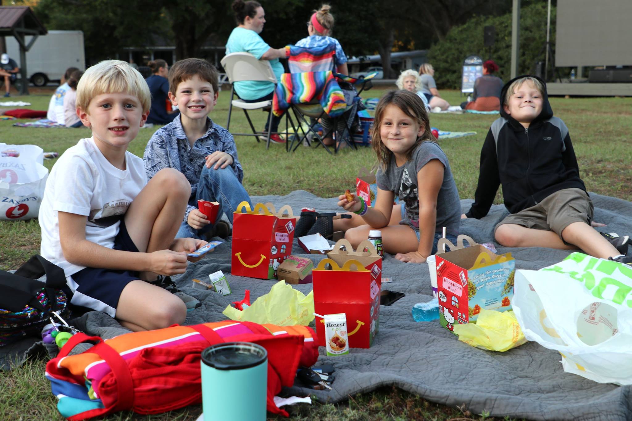 family sitting and smiling while they wait for the movie