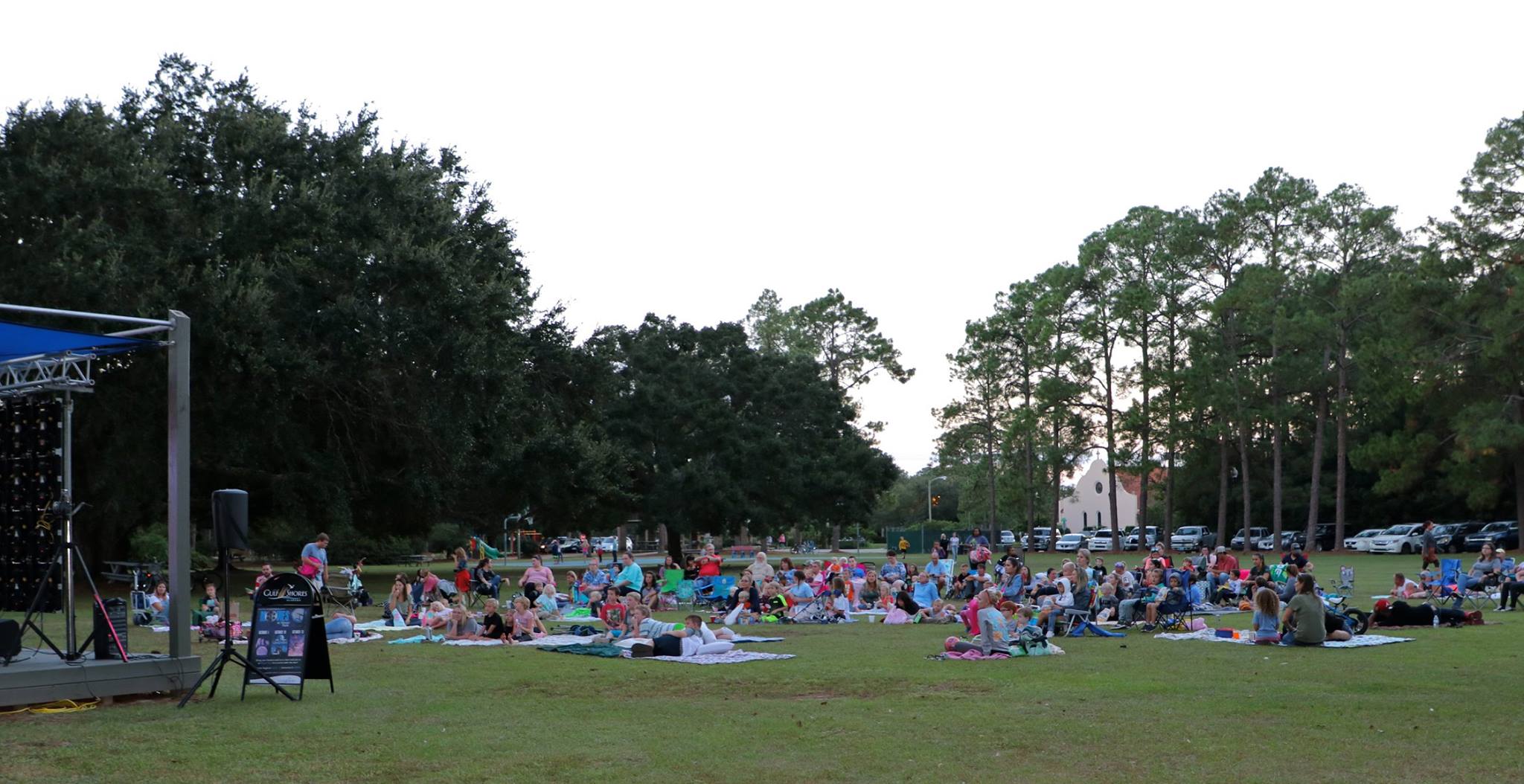 family sitting and smiling while they wait for the movie