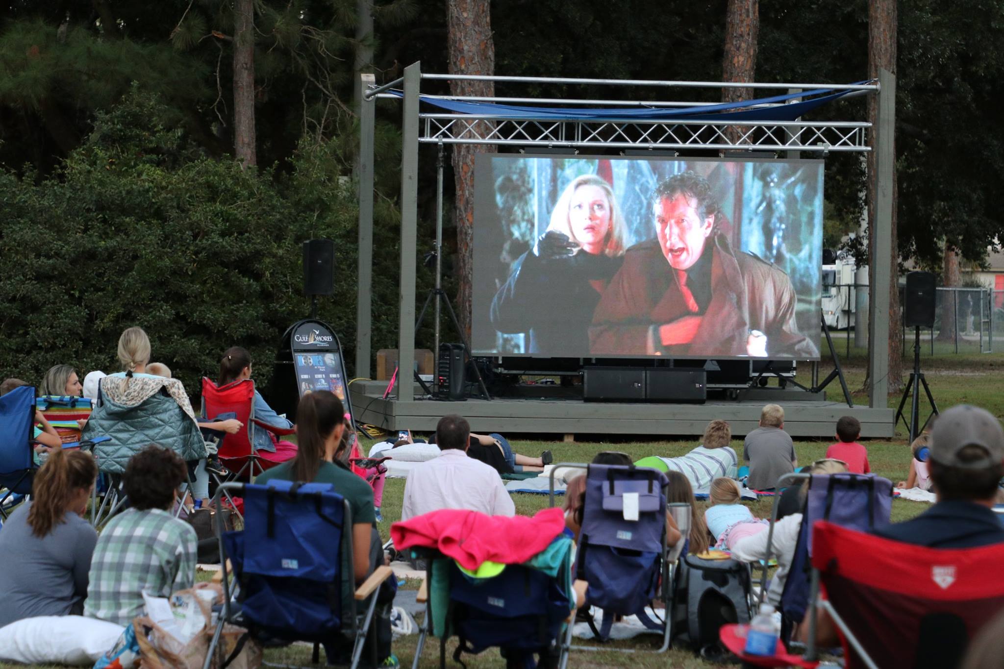 family sitting and smiling while they wait for the movie