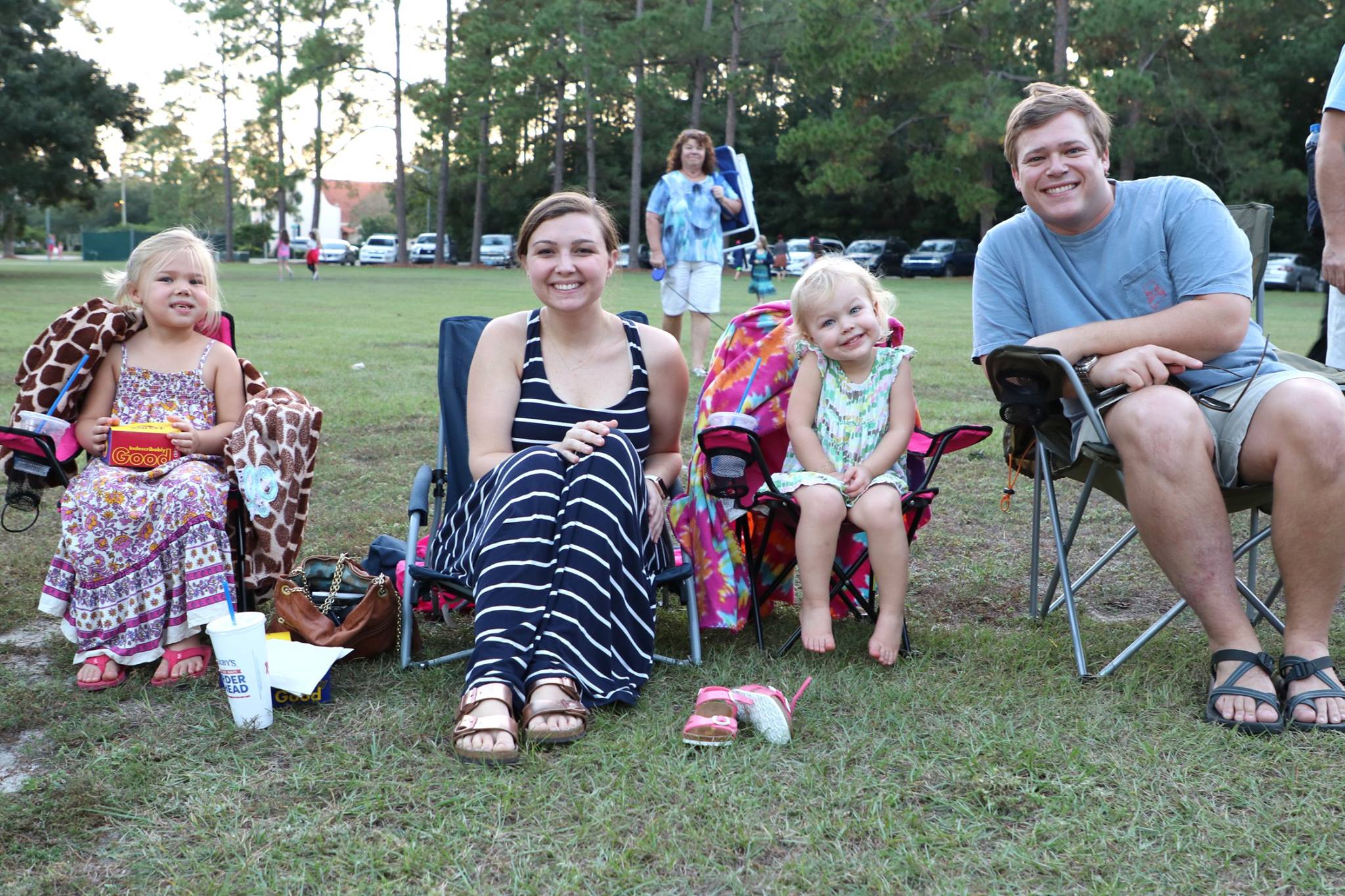 family sitting and smiling while they wait for the movie