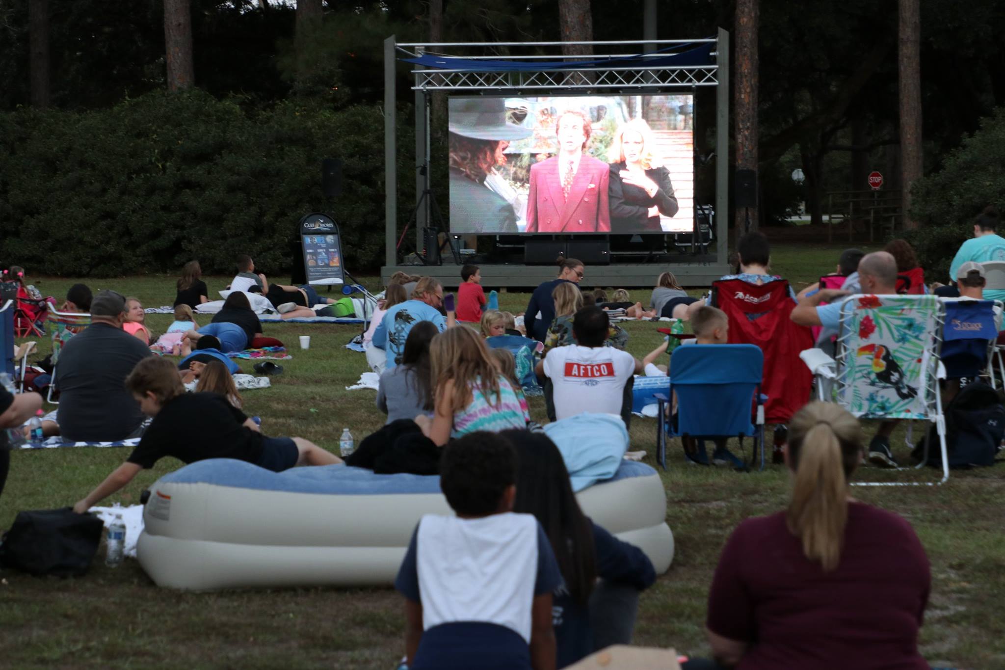 family sitting and smiling while they wait for the movie
