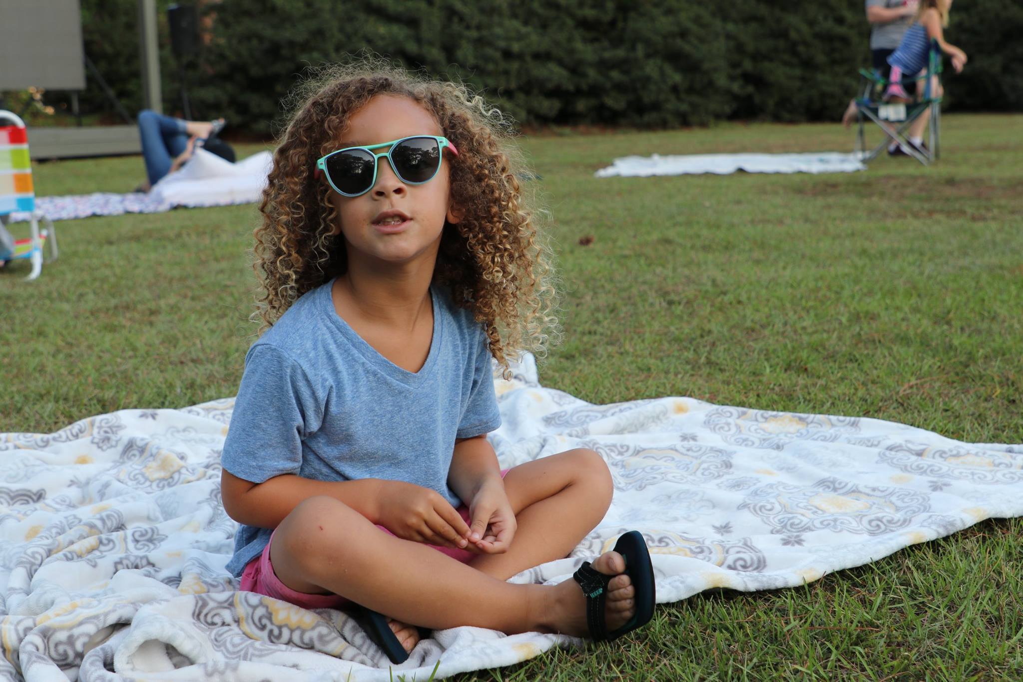 family sitting and smiling while they wait for the movie