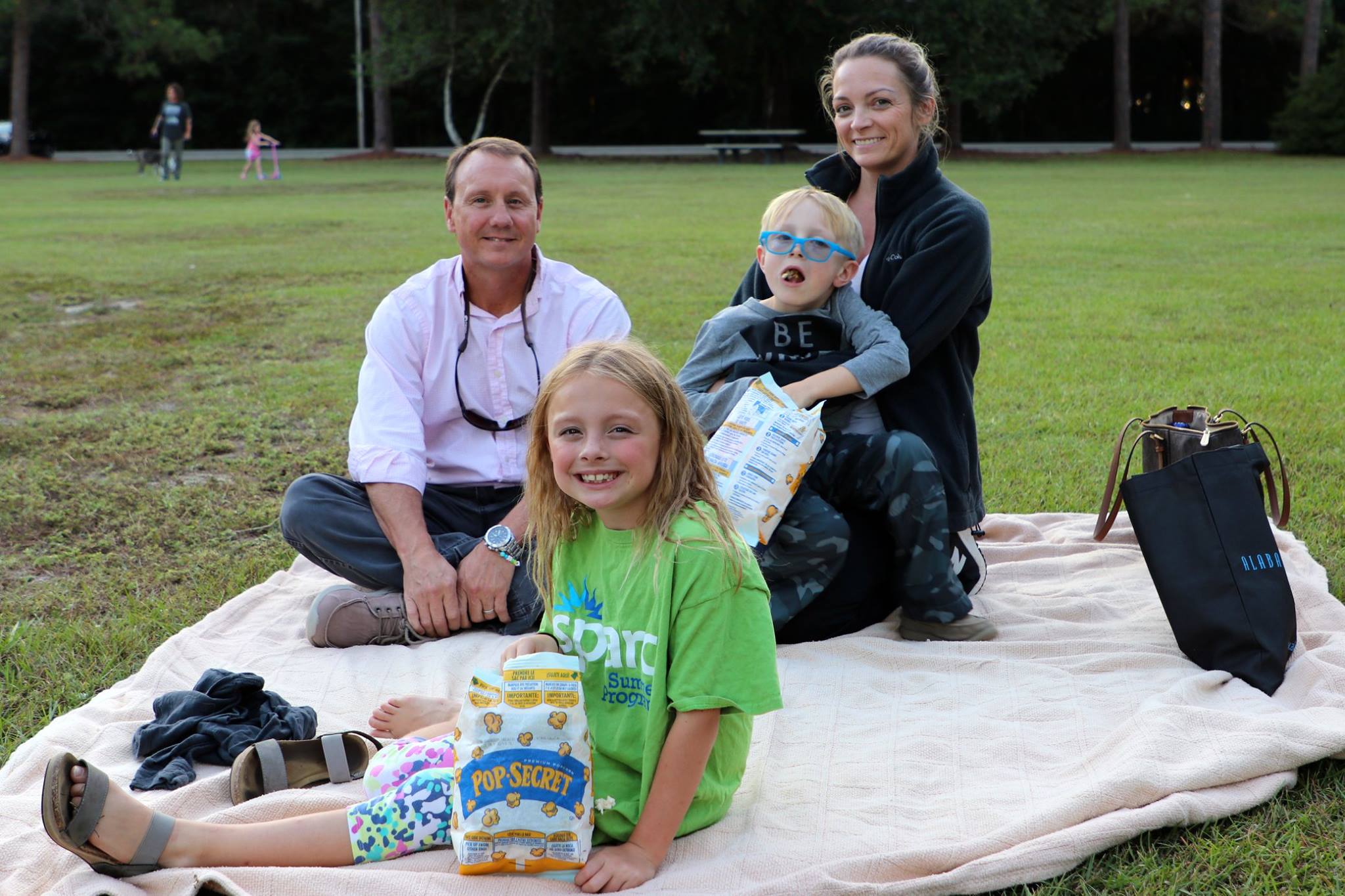 family sitting and smiling while they wait for the movie