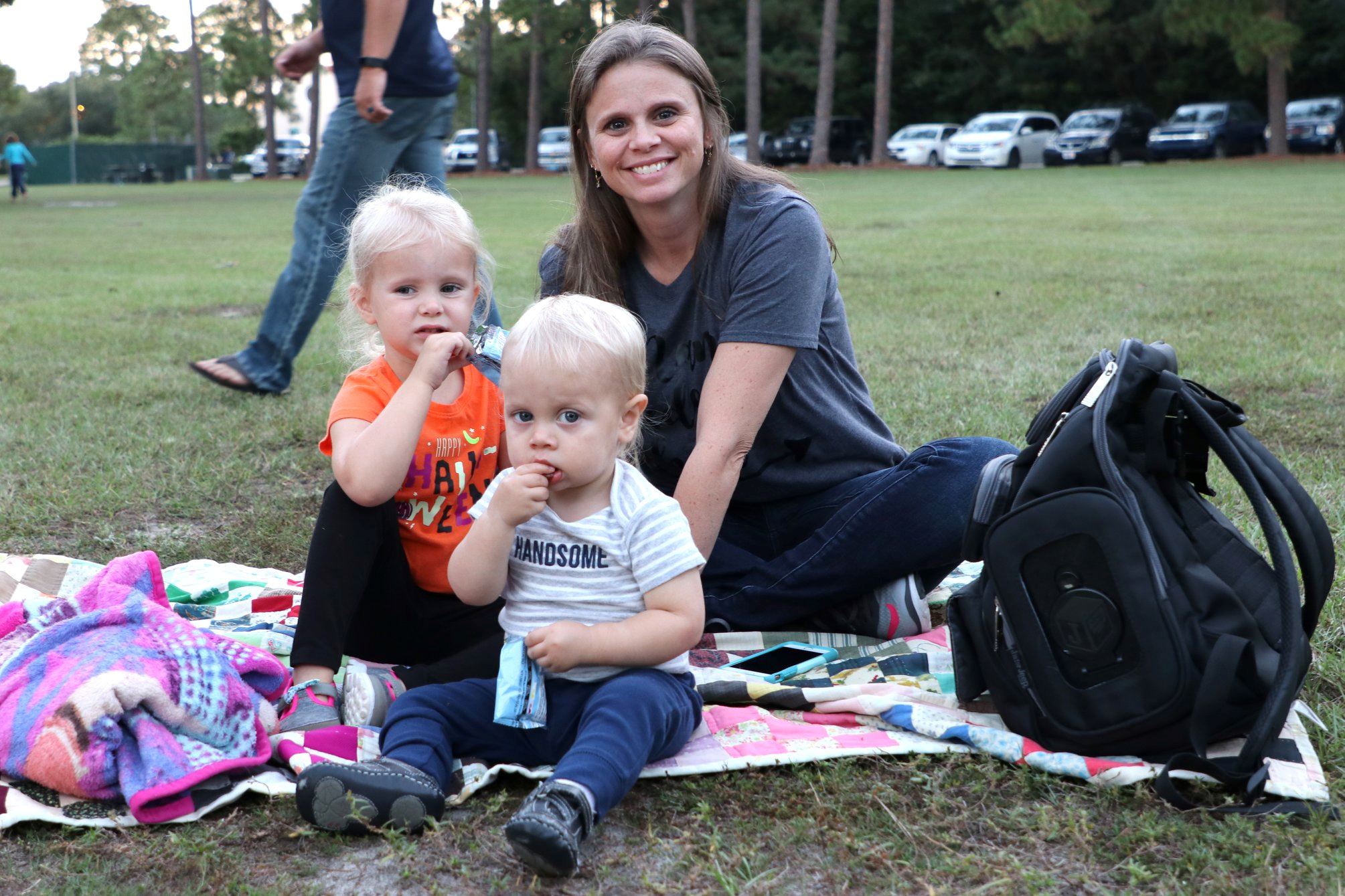 family sitting and smiling while they wait for the movie