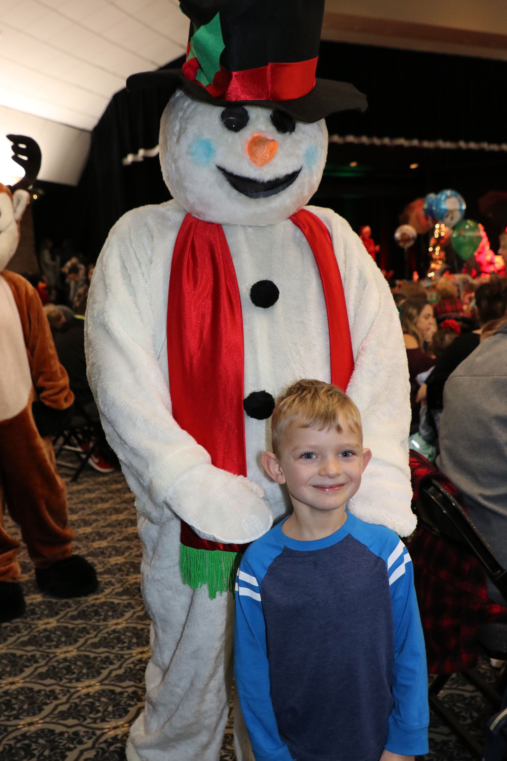 kid posing with frosty the snowman