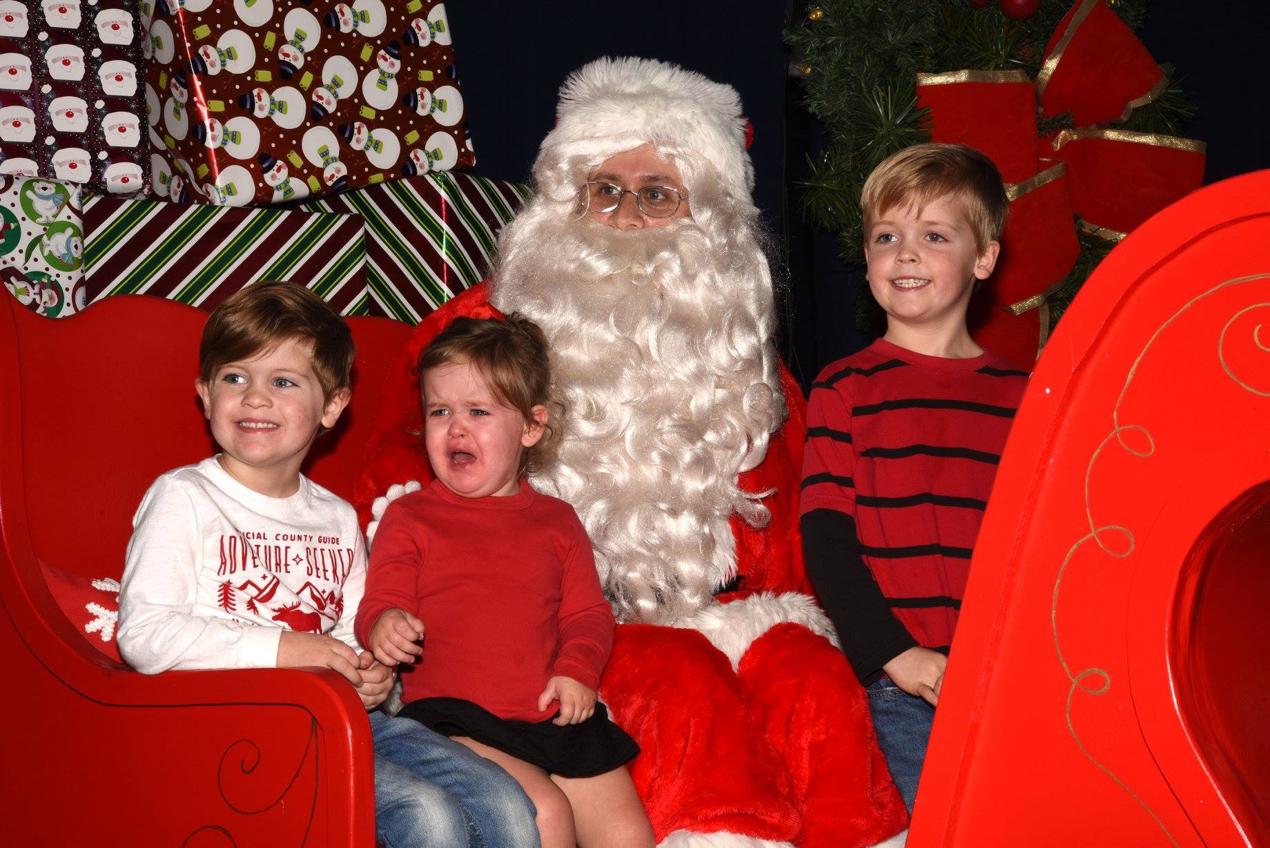 three kids sitting with Santa