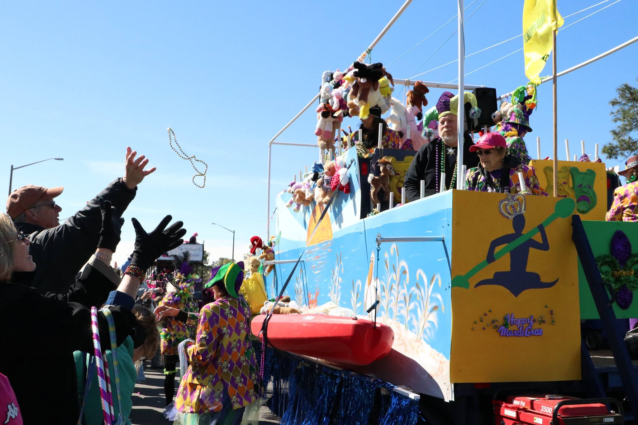 people throwing beads on mardi gras parade float