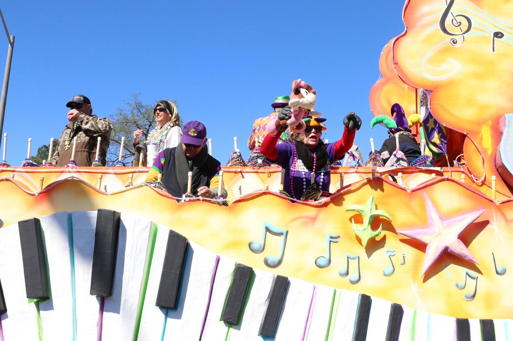 people throwing beads on mardi gras parade float
