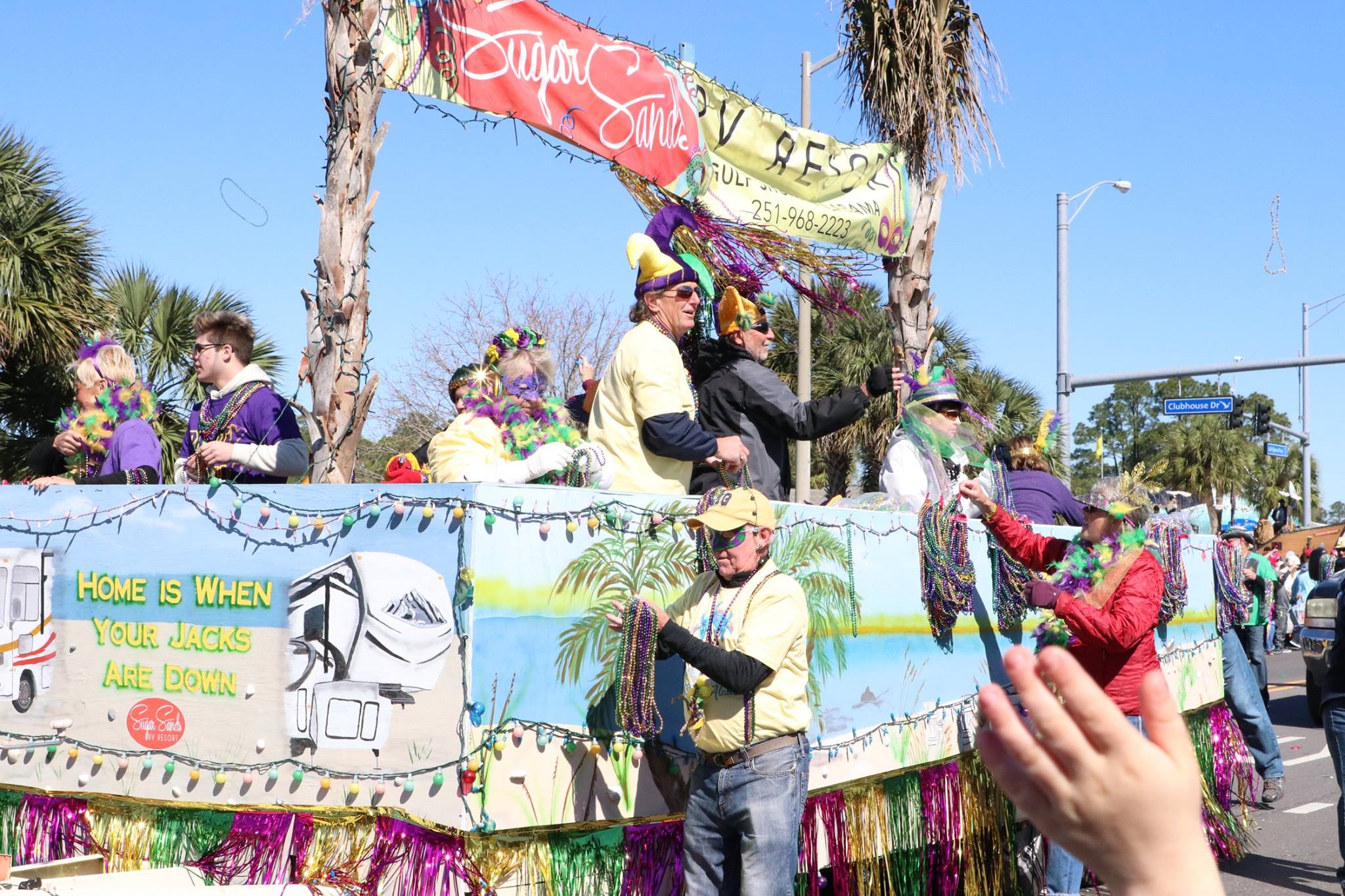 people throwing beads on mardi gras parade float