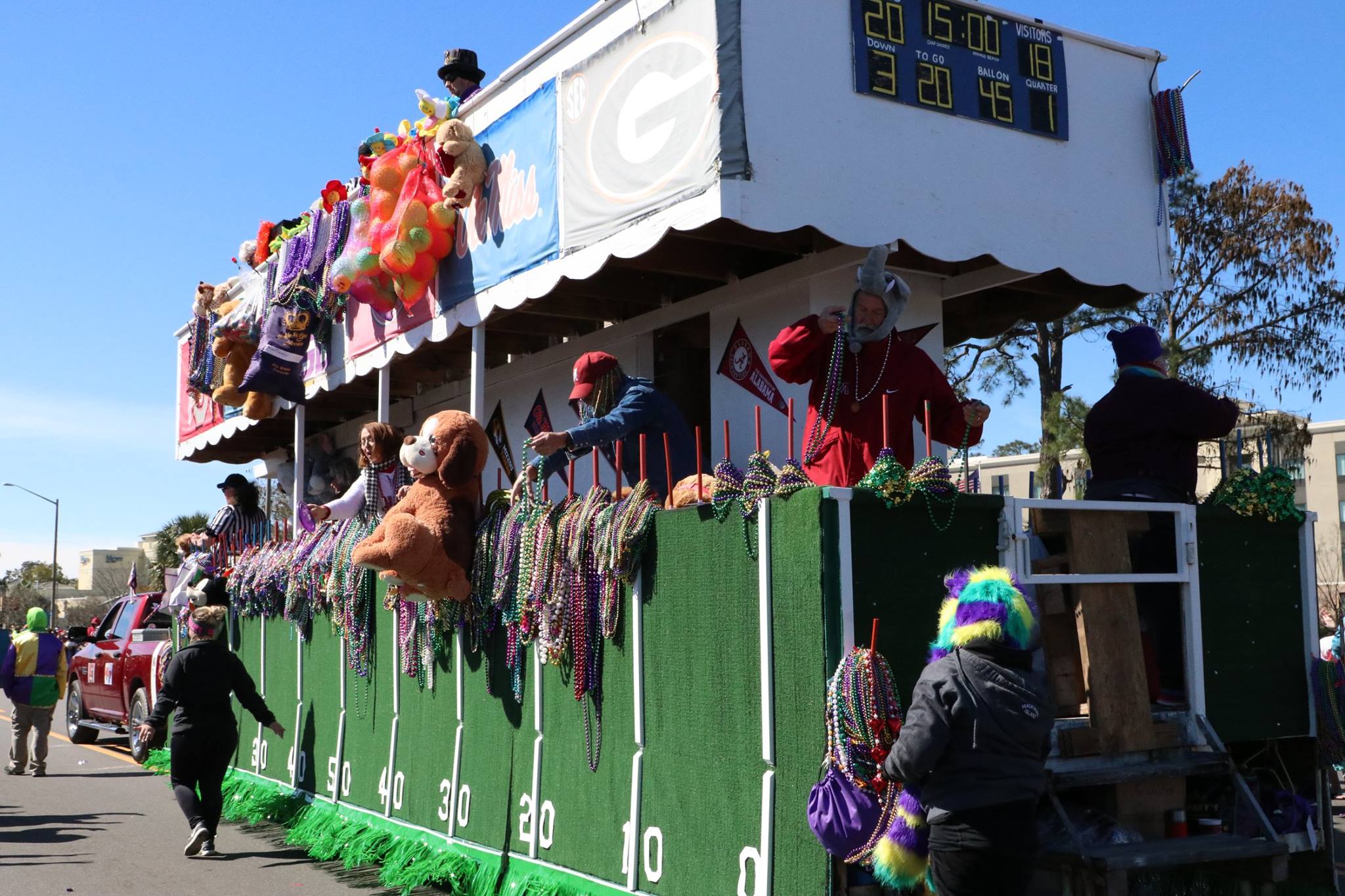 people throwing beads on mardi gras parade float