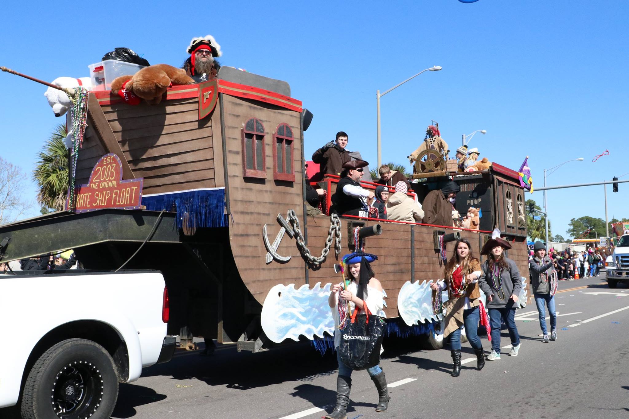 people throwing beads on mardi gras parade float