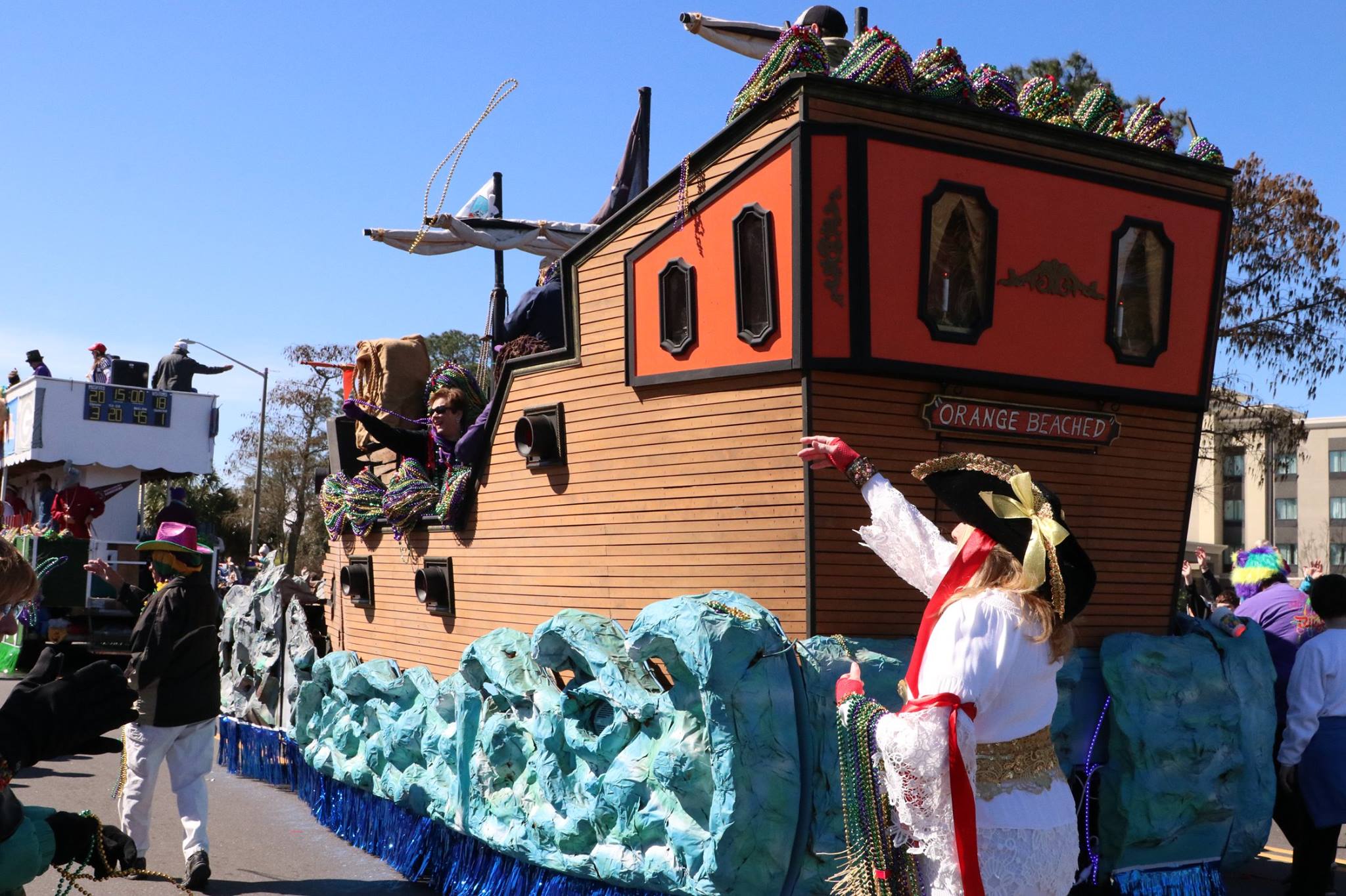 people throwing beads on mardi gras parade float