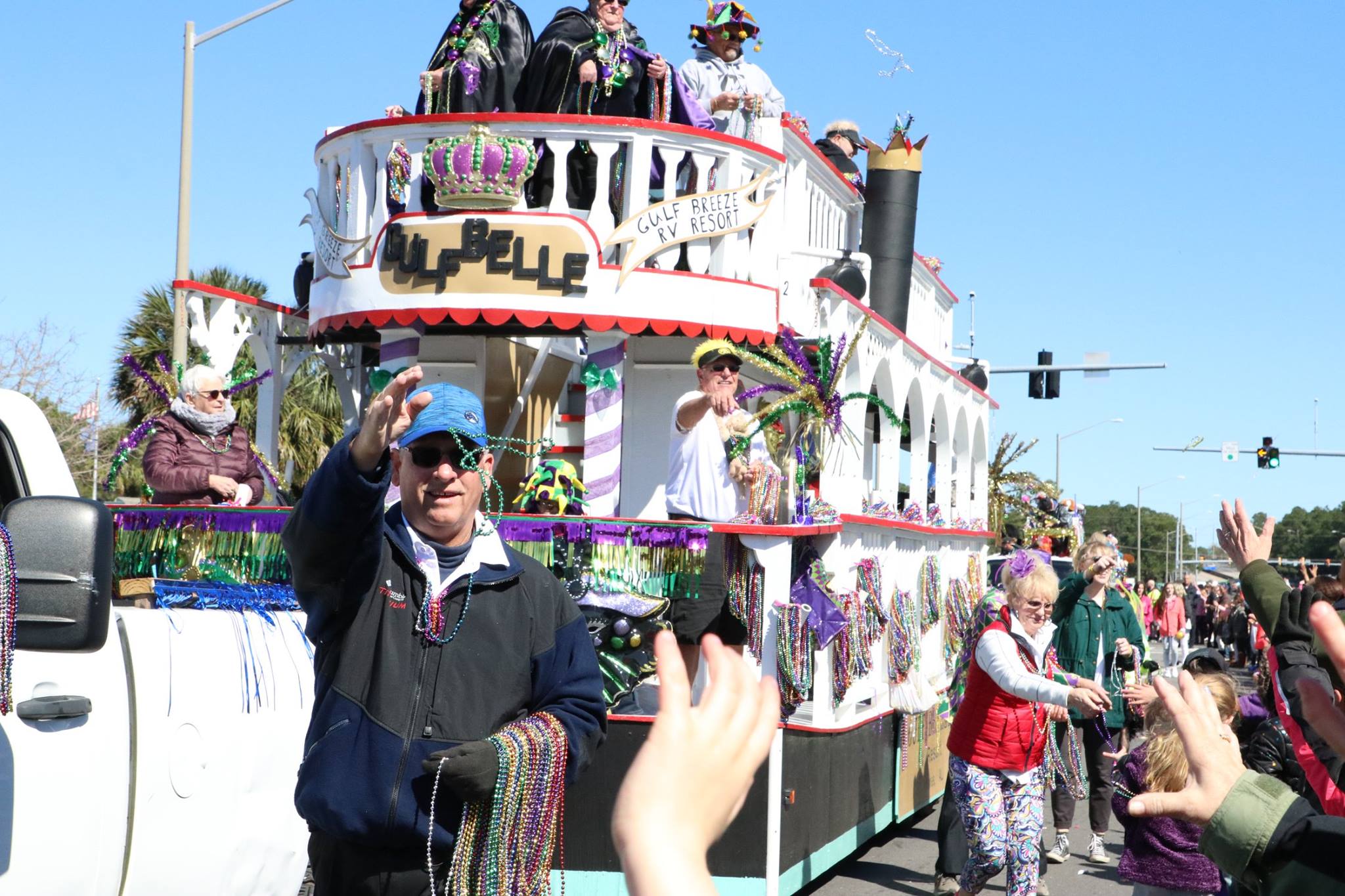 people throwing beads on mardi gras parade float