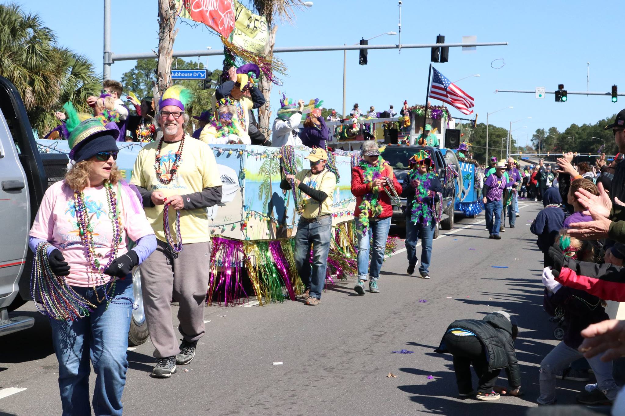 people throwing beads on mardi gras parade float